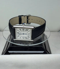 Cartier Tank in size L with a white dial, Roman numerals and a black leather strap, angled view