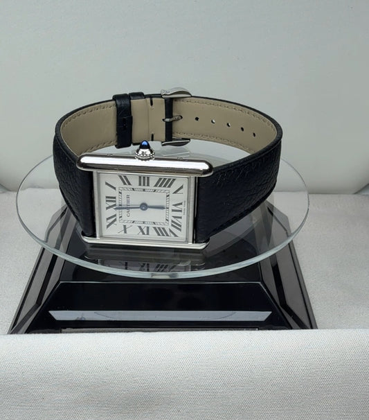 Cartier Tank in size L with a white dial, Roman numerals and a black leather strap, angled view